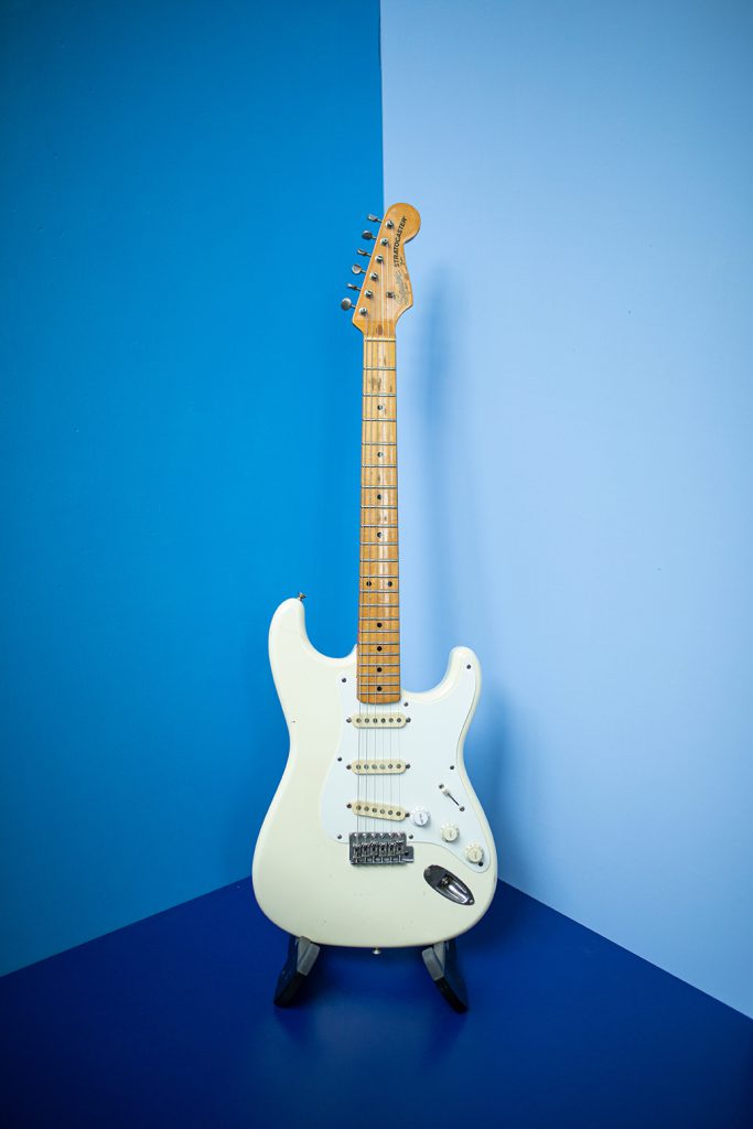 Weiße-e-gitarre-in-blauer-ecke