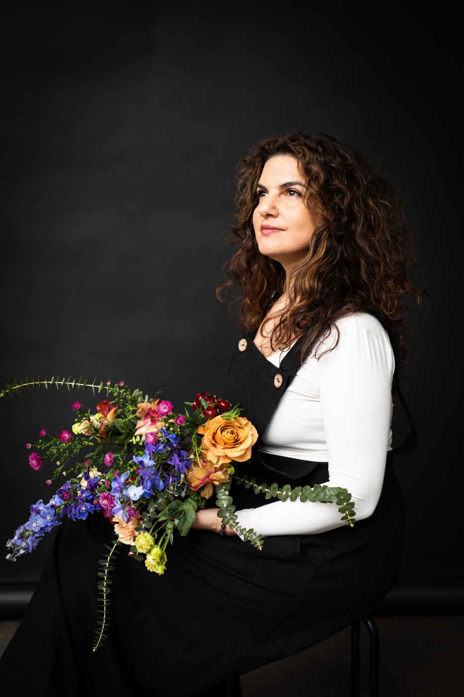 Sinemstraughan-by-nadine-Heller-Menzel-Frau-mit-Blumenstrauß-vor-schwarzem-Hintergrund