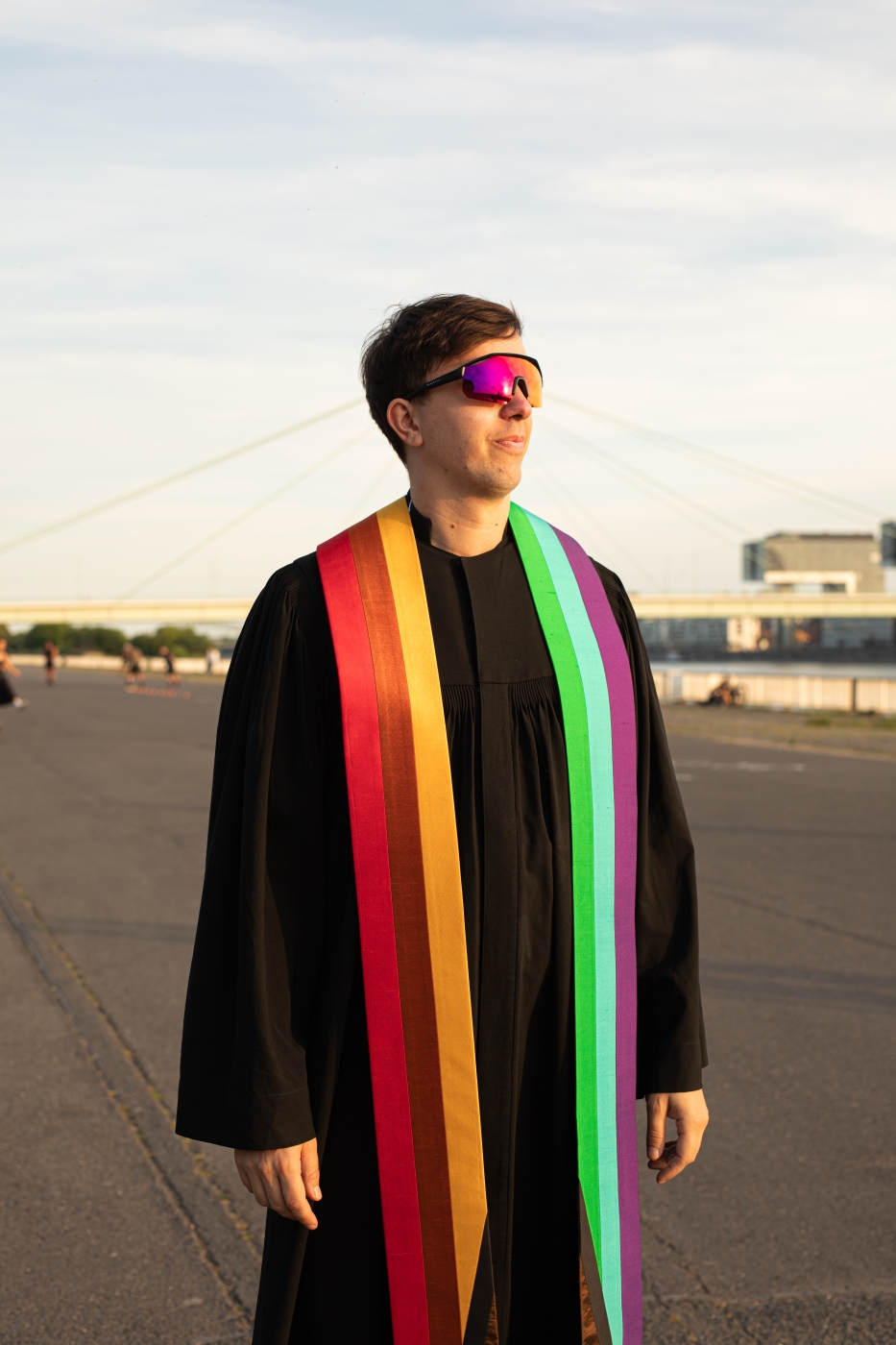 Pfarrer-und-Kircheninfluencer-Tim-Lahr-am-Deutzer-Hafen-Köln-trägt-schnelle-Brill-Talar